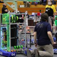 An event worker helps with technical issues on the field